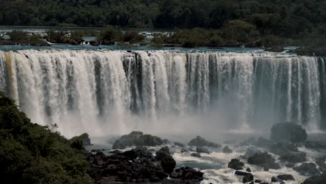 water flowing down on iguazu waterfalls with rocks in downstream