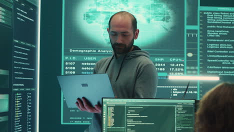 Governmental-hacker-examines-info-on-a-big-screen-in-agency-office