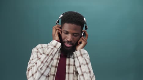 an african young man in a white shirt is listening to music and dancing