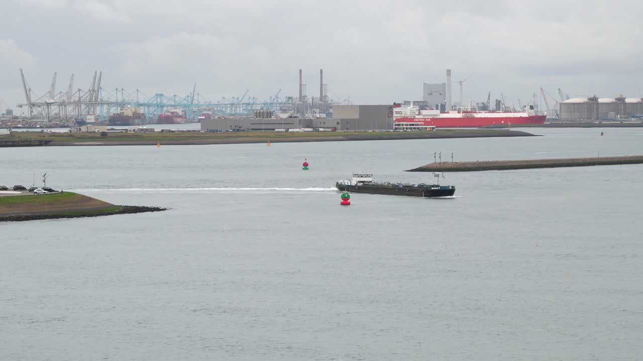 Boat leaving Calandkanaal in Dutch logistics and industrial area