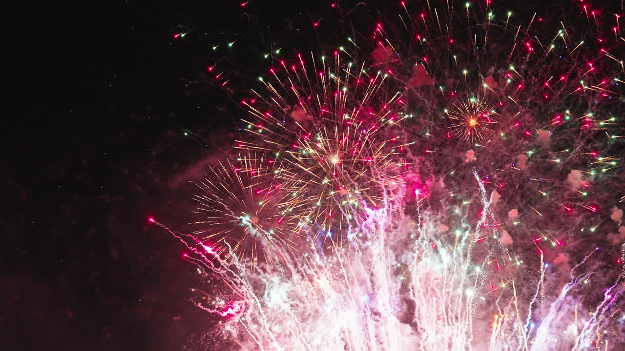 Wide angle fireworks show capturing full spread of night sky bursts
