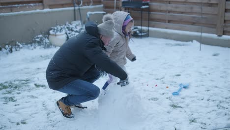 grandfather and granddaughter having fun in the snow