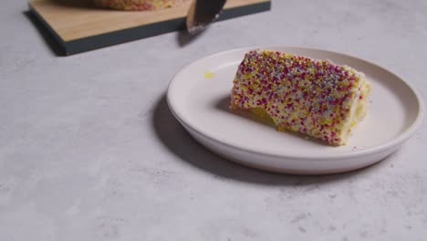 close up shot of slice cut from rainbow celebration cake on plate 1