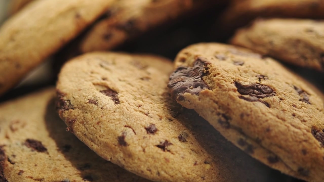 Primo piano di biscotti con gocce di cioccolato appena sfornati su un piatto.