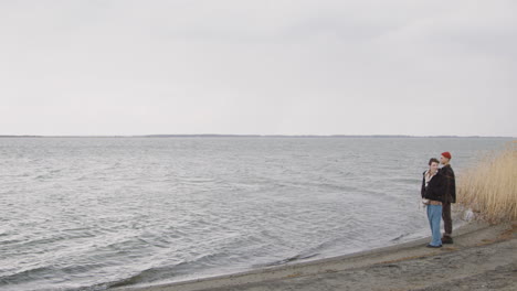 Teenage-Boy-And-Teenage-Girl-Standing-Near-Of-Seashore-On-A-Cloudy-Day