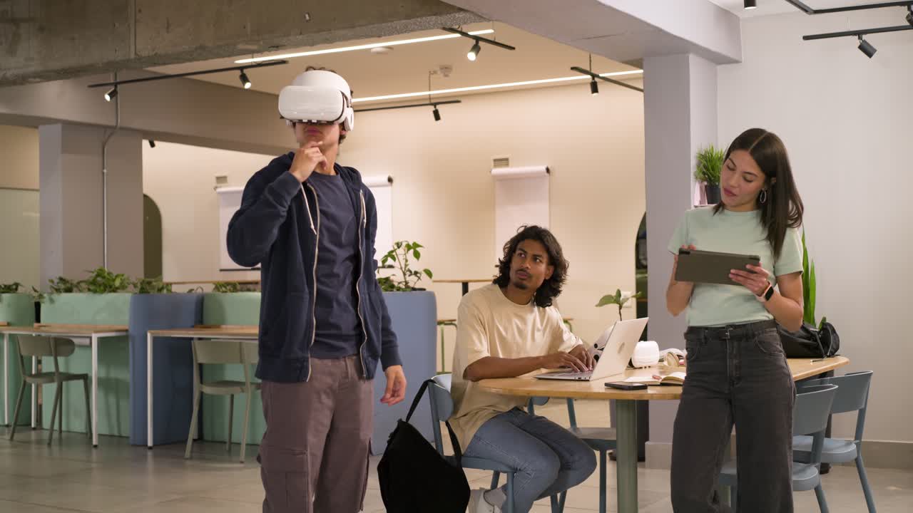 Mangfoldig team ser på mannlig tester som justerer hvitt VR-hodesett og demonstrerer bevegelser med et nettbrett på et kontor.