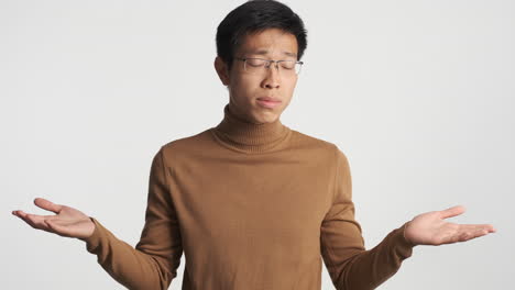 asian man showing i don't know gesture.