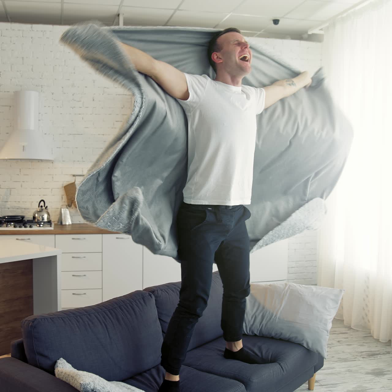 Happy man on bed. Young man waking up and began to joy waving blanket. Cheerful man recovered from the disease. Healthcare concept
