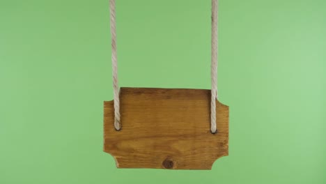 wooden signboard hangs from the ropes. isolated