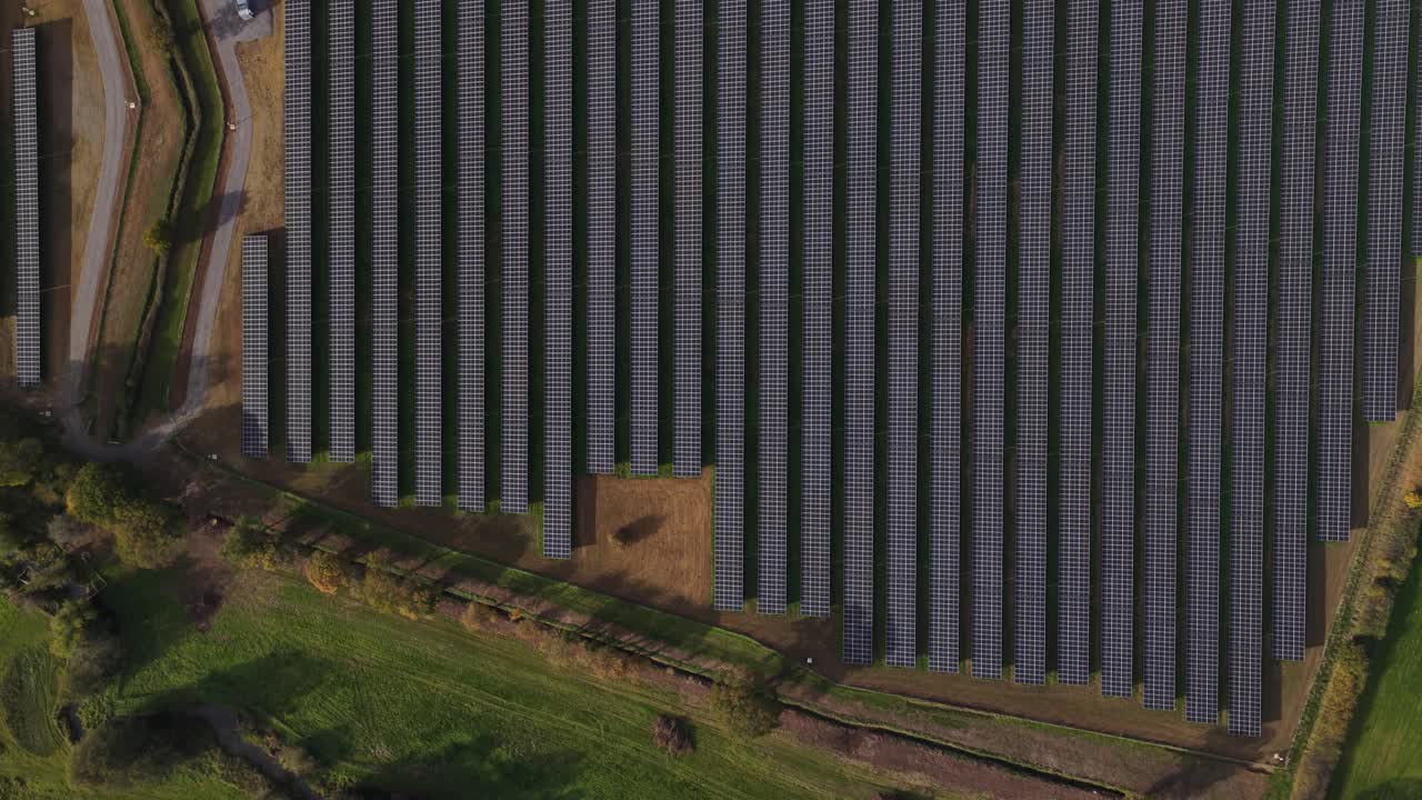 Aerial drone view of solar panel fields in the Kent countryside, showcasing clean renewable energy generation and the growing shift toward sustainable power in the United Kingdom