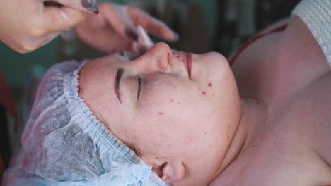 beautician removes foamy mask from woman face after massage