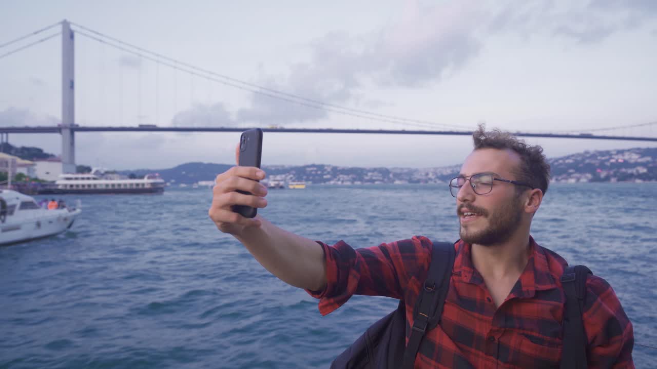 llamada de video contra el puente y vista de la ciudad en el mar. ciudad de istanbul.