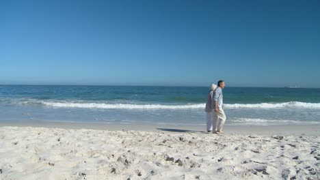 Älterer-Mann,-Der-Mit-Seiner-Frau-Am-Strand-Spaziert