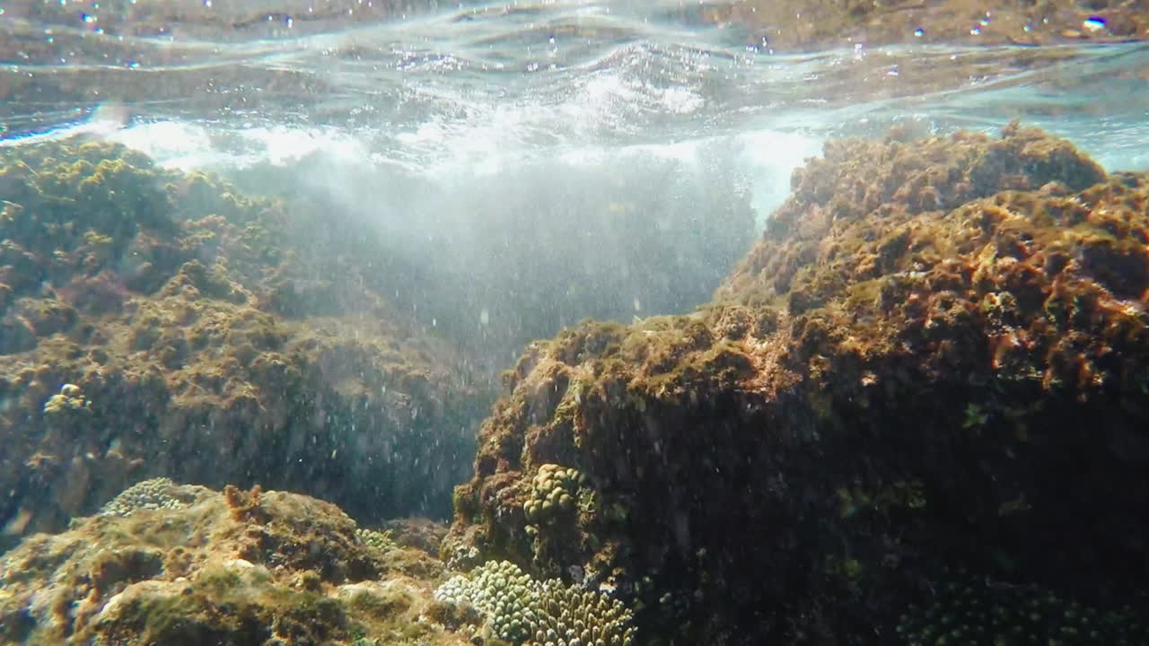 olas rompiendo en las rocas - bajo el agua