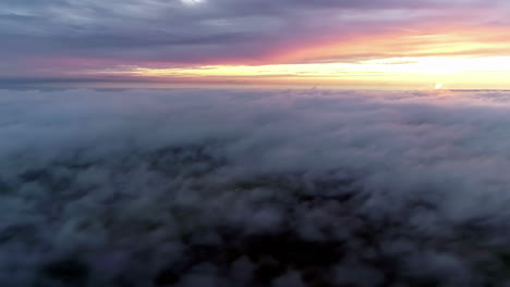 aerial above dramatic beautiful golden sun sunset over thick clouds