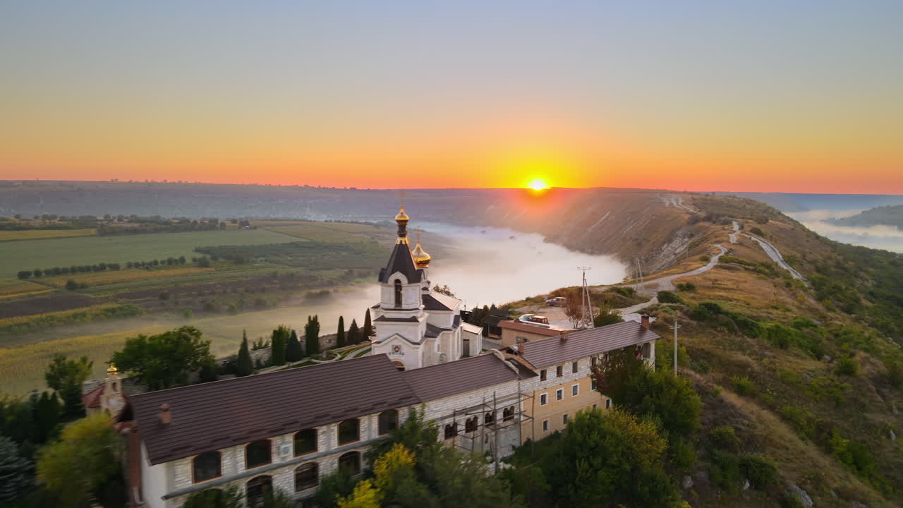Aerial drone view of the Old Orhei at sunset. Valley with river and fog, village, monastery located on a hill in Moldova