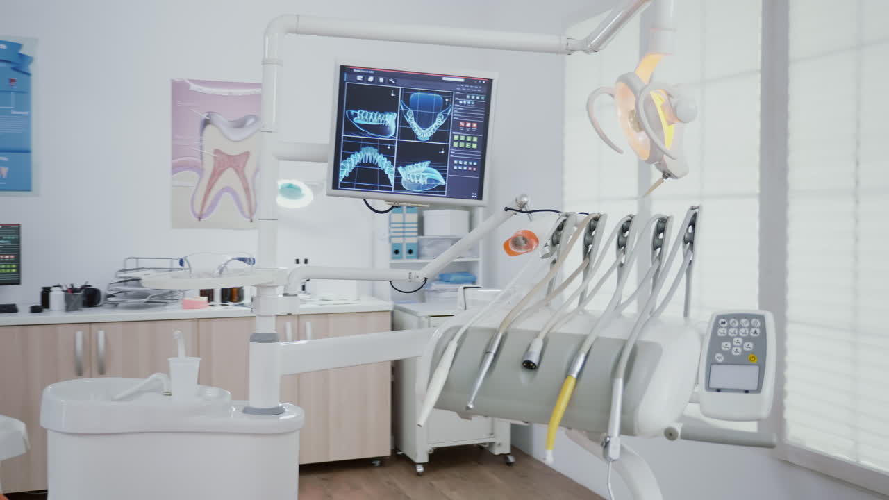 Revealing shot of orthodontist chair with nobody in, dental x ray images on display