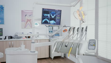 revealing shot of orthodontist chair with nobody in, dental x ray images on display