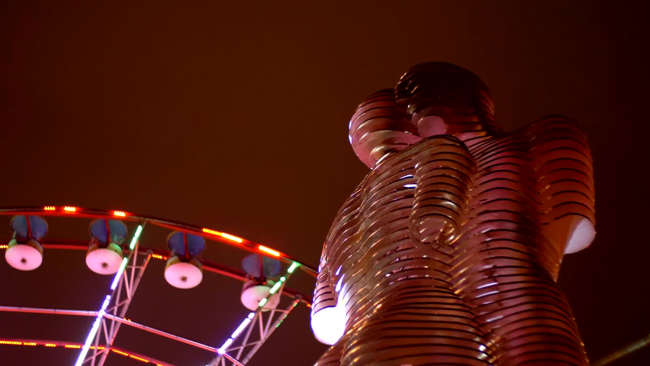 estatua de ali y nino en una rueda de ferris de fondo por la noche en el terraplén de batumi, georgia
