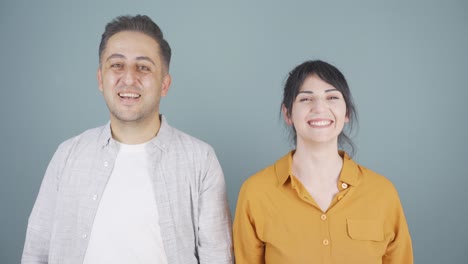 couple making a sign of confidence at the camera. confidence message.