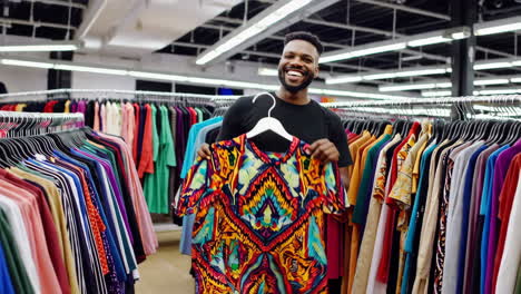 happy man shopping for colorful clothes in a store