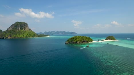 Impresionante-Toma-Aérea-Ascendente-Sobre-Pequeñas-Islas-Tropicales-En-Medio-De-Un-Océano-Colorido