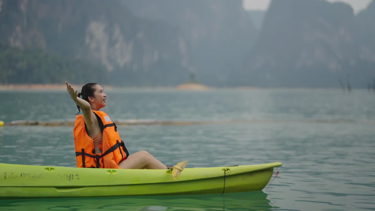 Woman enjoying kayaking on a scenic mountain lake