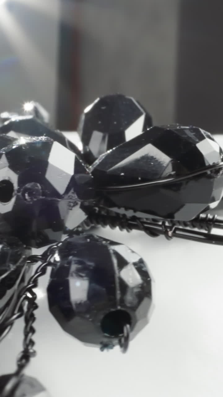 색 표면에 빛이 반사되는 목걸이의 반이는 검은색 면이 있는 구슬