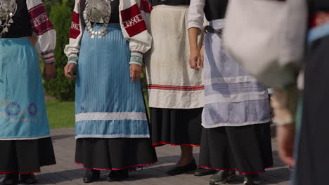 traditional estonian women dancers wearing national dresses-outfits, folk colorful costumes, ornate clothes and silver jewelry around their neck, estonia cultural dance performance