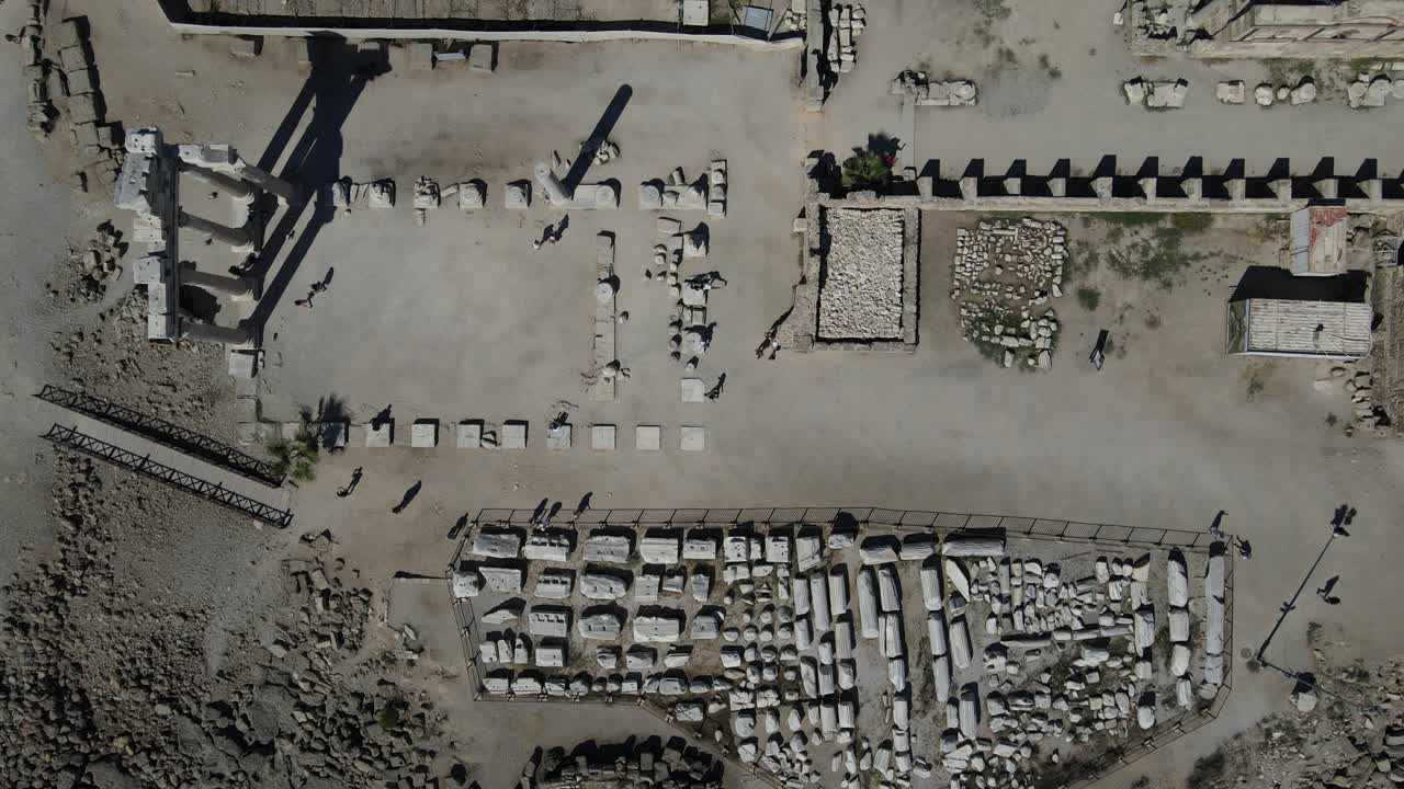 역사적 기둥 들 사이 를 산책 하는 관광객 들