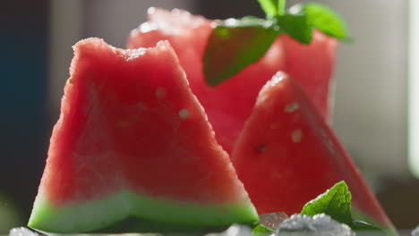 pieces of watermelon on the table with falling ice