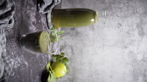 vertical video of male hand putting glas of green smoothie or juice on table