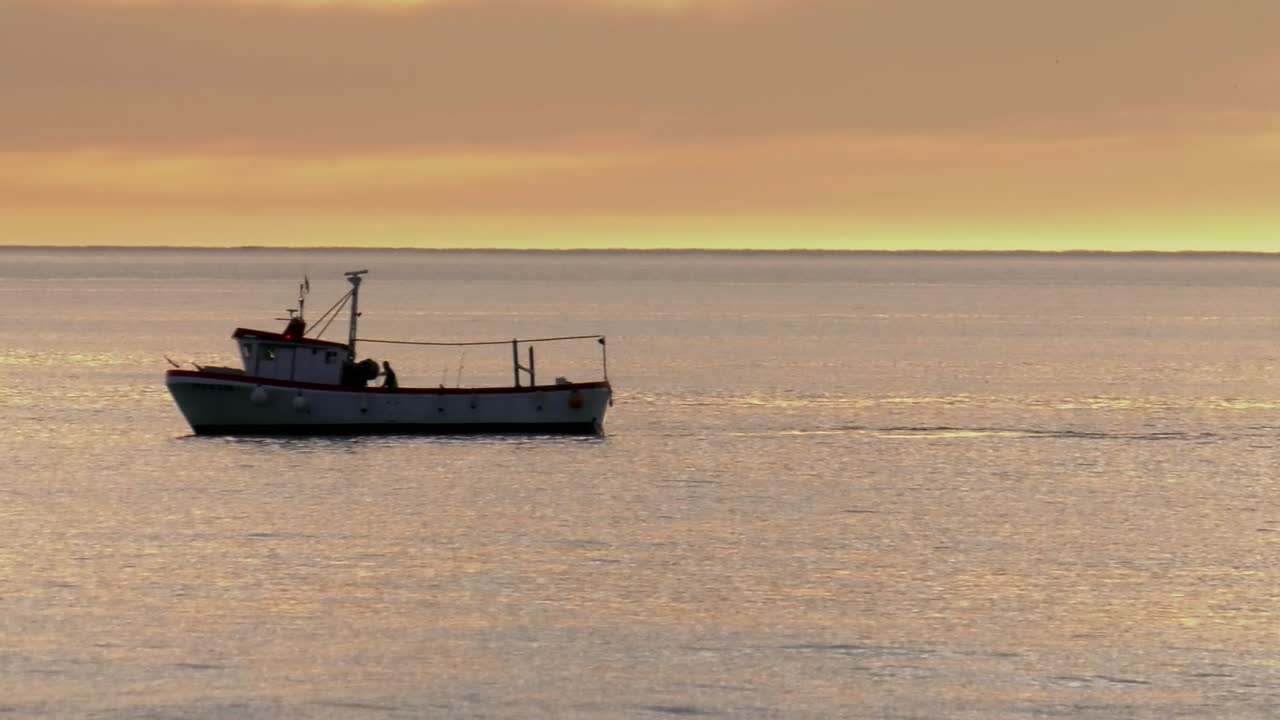 Fishermen on Fishing boat on calm sea at dawn