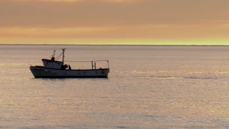 fishermen on fishing boat on calm sea at dawn
