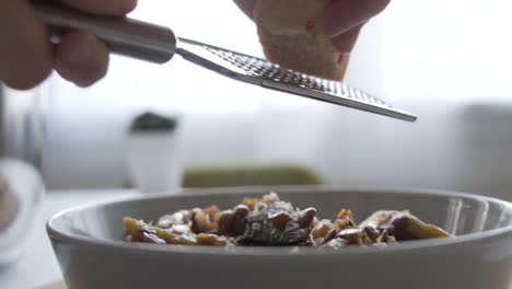 toma en cámara lenta como queso raspando encima de la comida.