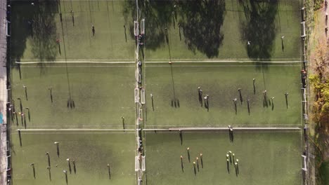 lapso de tiempo de arriba hacia abajo: muchos futbolistas corriendo en el campo de fútbol durante la sesión de entrenamiento a la luz del sol - muchos campos de fútbol en la universidad de buenos aires - vista aérea superior