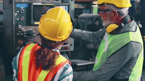 group of factory workers using machine equipment in factory workshop