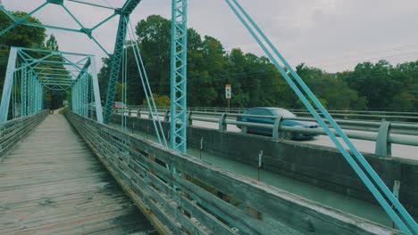 a heavy flow of cars travel over a bridge sitting above a steady river