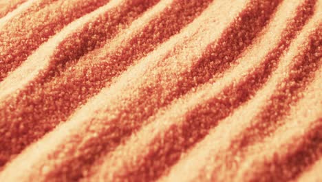 Video-of-close-up-of-orange-coloured-sand-with-pattern-and-copy-space-background