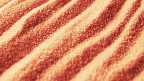 video of close up of orange coloured sand with pattern and copy space background