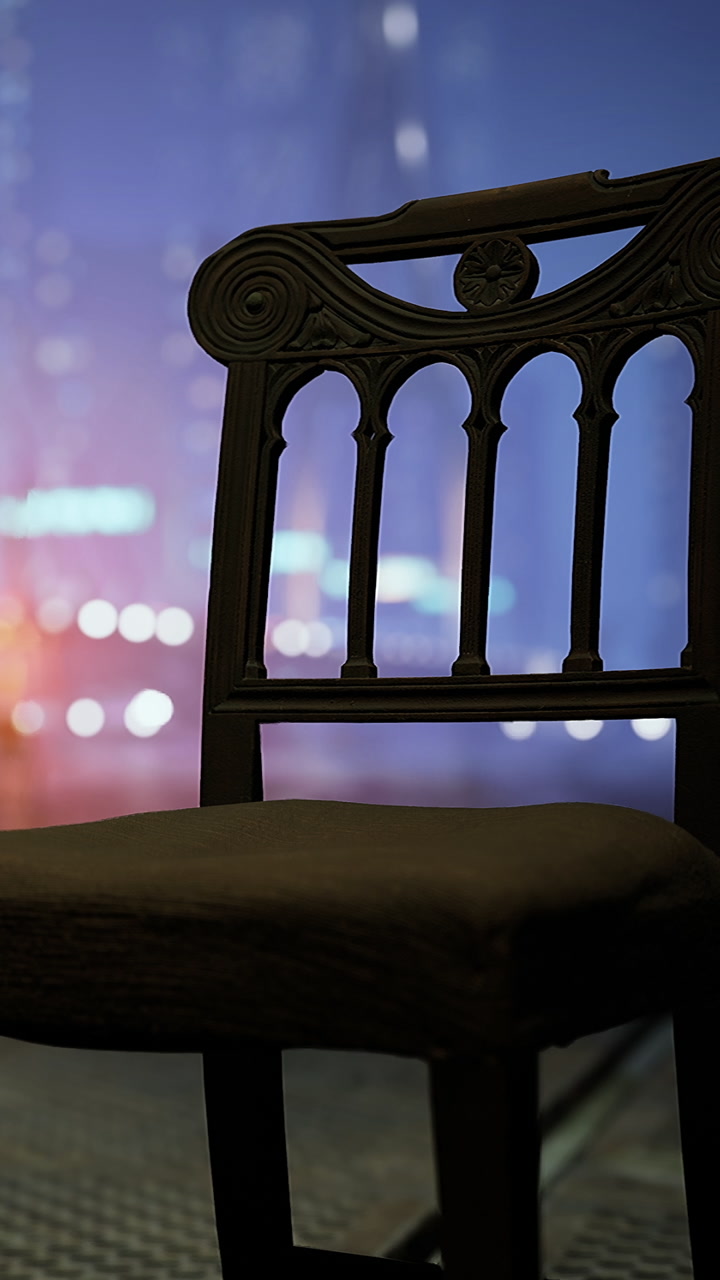 Wooden chair placed in front of a blurred city background at night