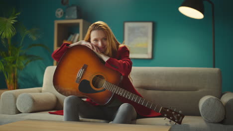 woman sitting on sofa with a guitar