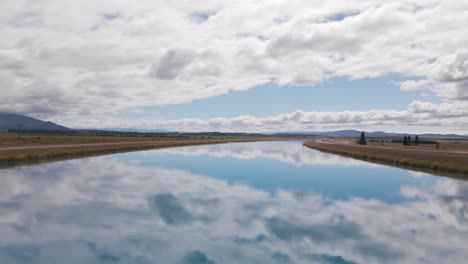 Ein-Fesselnder-Anblick-Von-Wolkenfetzen,-Die-Sich-In-Den-Kanälen-Des-Pukaki-sees-In-Neuseeland-Spiegeln,-Während-Sie-Am-Himmel-Darüber-Treiben