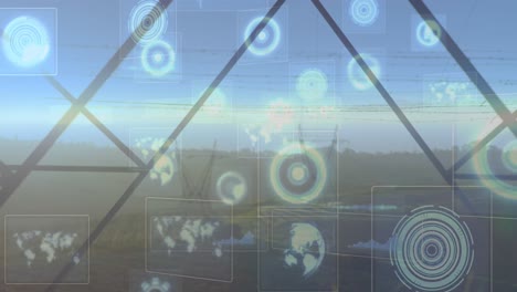 Animation-of-hud-interface-with-circles,-globe-and-map-over-electricity-pylons-on-landscape