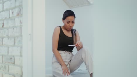 mujer mirando una prueba de embarazo