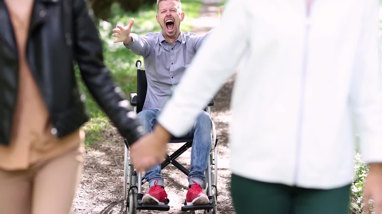 To unge kvinner forlater en frustrert mann i rullestol 4K-film