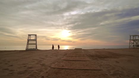 caminando por la playa al atardecer. grupo de amigos grupo descansando en la playa