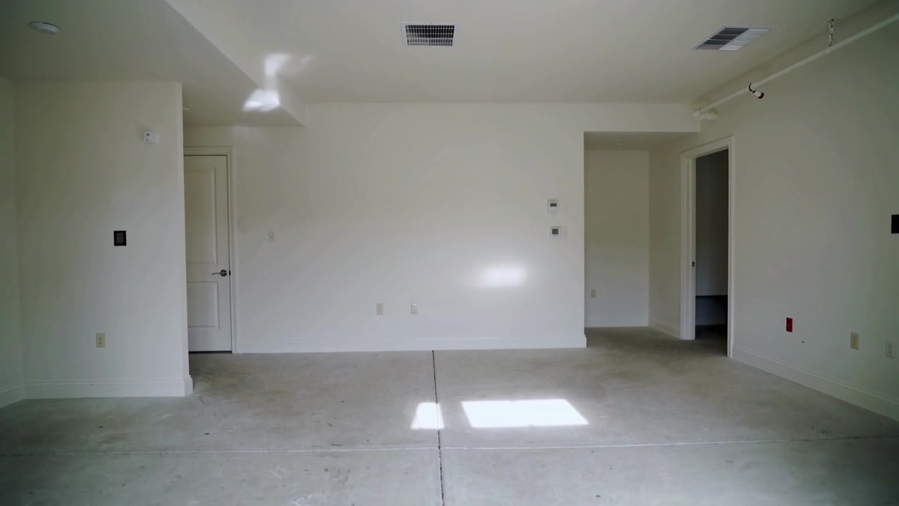 Una chiazza di luce solare che si sposta sul pavimento di cemento del garage a causa del movimento del sole, mostrando il passare del tempo.