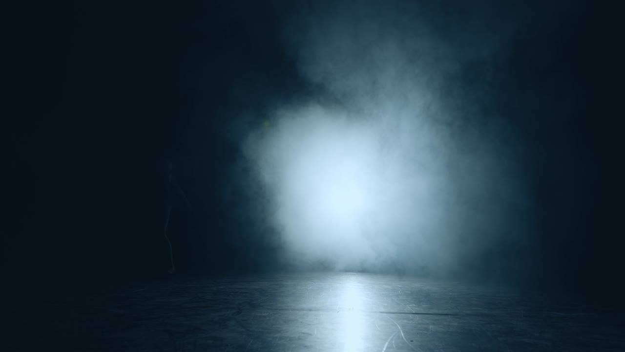 volando, libertad. graciosa bailarina de ballet en la nube de humo y los reflectores. bailarina de ballet flexible moviéndose en la niebla