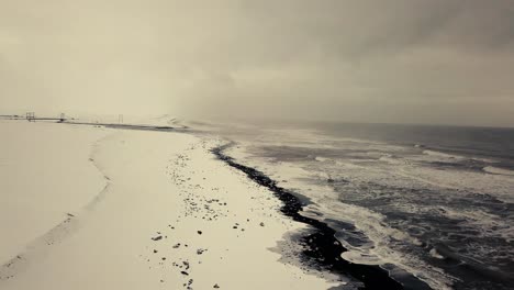 Cinematic-drone-moves-show-Black-sand-beach-in-Iceland-filmed-by-drone-in-snowy-conditions